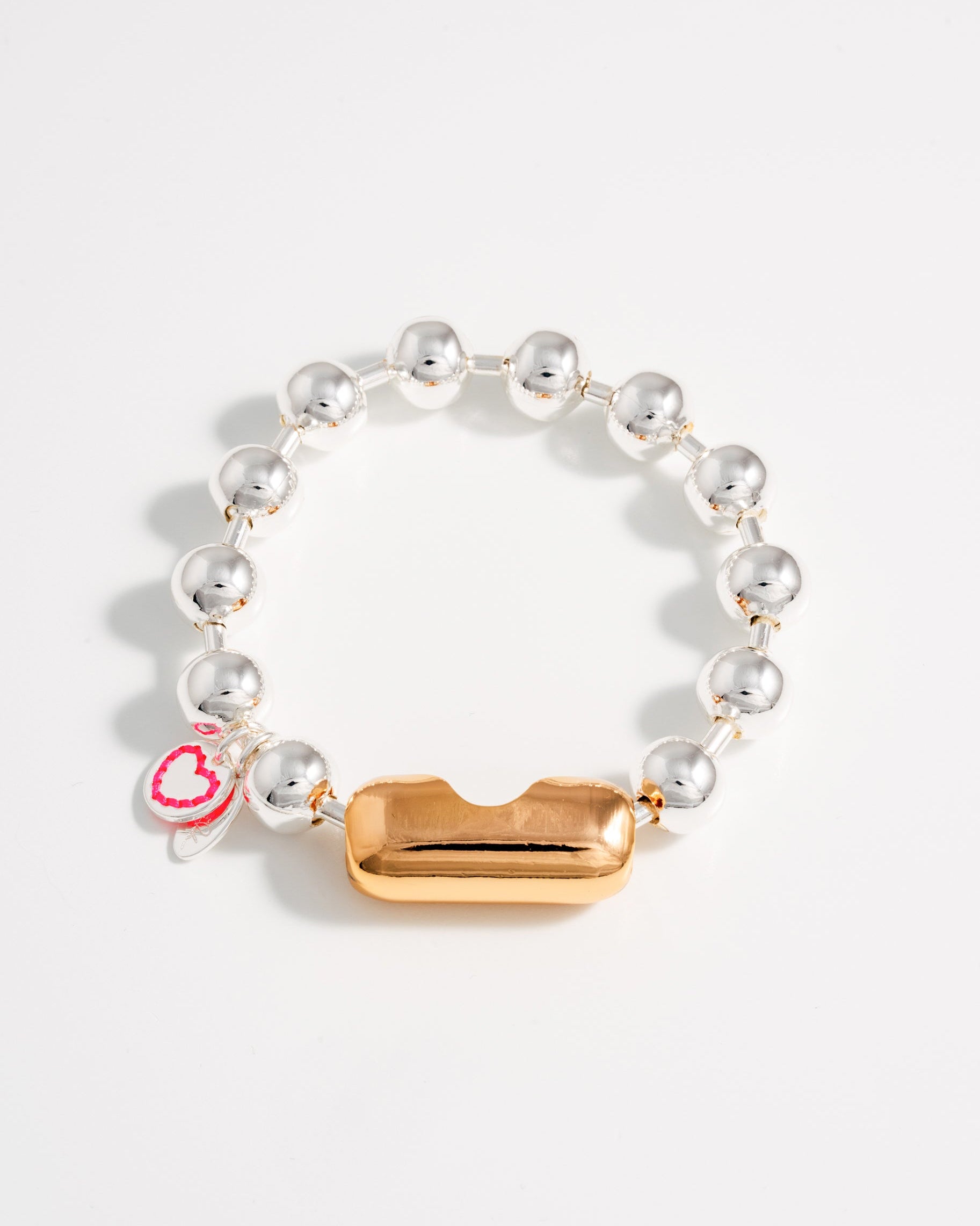 A bracelet with silver balls and link chain, featuring a gold clasp, and a small red tag.