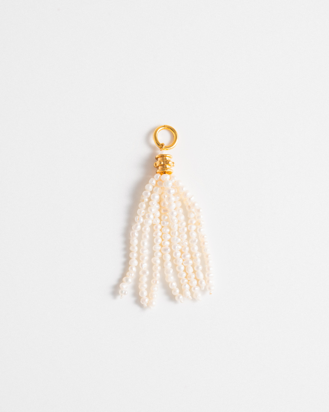 Pearl tassel charm with gold accent on a white background
