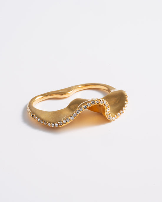 A gold wave-shaped ring with delicate pave detailing, designed to be worn on two fingers.
